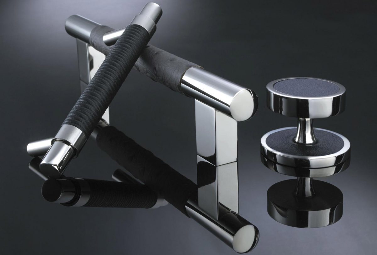a selection of Colonial Bronze cabinet knobs and drawer pulls against an elegant black background with reflective surface